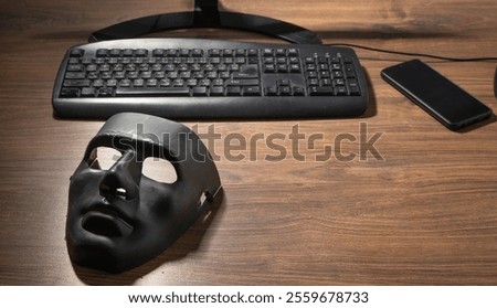 Black mask and computer on the table.
