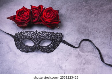 Black masquerade mask made of lace and three roses on a gray background - Powered by Shutterstock