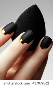 Black matte nail polish. Manicured nail with black matte nail polish. Manicure with dark nailpolish. Golden nail art manicure