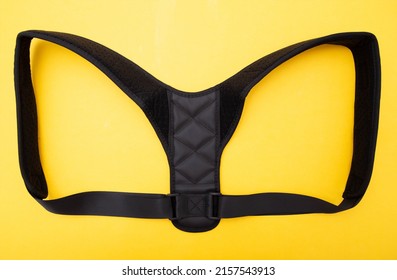 Black Medical Corset For The Treatment Of Back And Posture On A Yellow Background, Close-up.