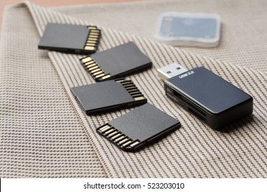 Black memory cards and card reader on textile background