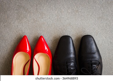 Black Men Shoes And Red Women Shoes On Gray Background