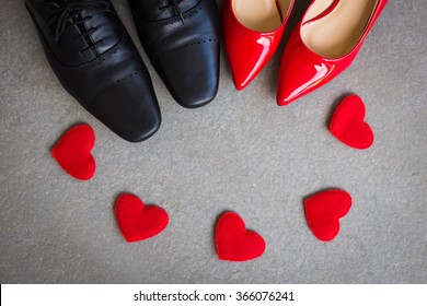 Black Men Shoes And Red Women Shoes With Red Heart On Gray Background