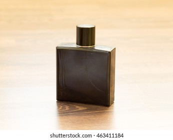 Black Men's Cologne On A Wooden Table