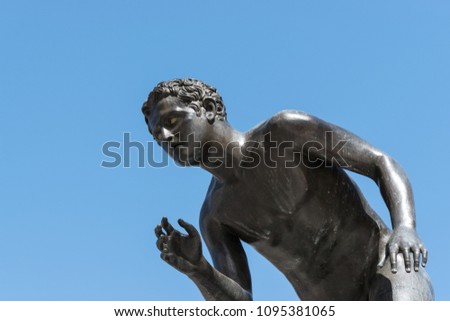 Black metal or bronze statue of a boy.