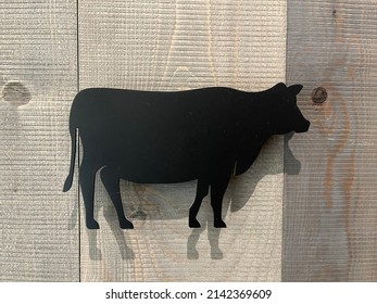 Black Metal Cow In Wood Background