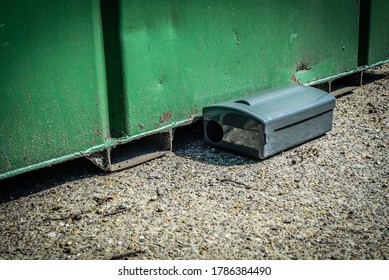 Black Metal External Rodent Rat Bait Station Outside Against A Metal Container Wall Close Up.  Pest Control.