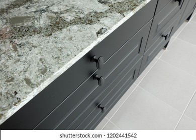 Black Metal Handles On Wooden Drawer And Front Door Of Kitchen Cabinet Under Stone Worktop .