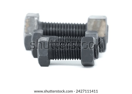 Black metal hexagonal bolts and nuts shown in close-up isolated on white background