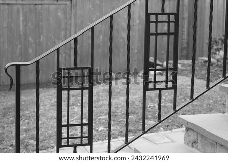 The black metal riling has a pattern in it.