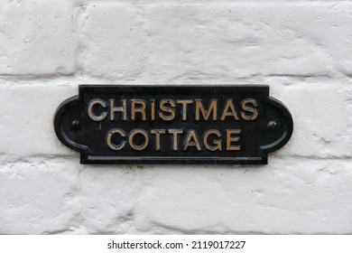 Black Metal Sign On A White Wall - Christmas Cottage