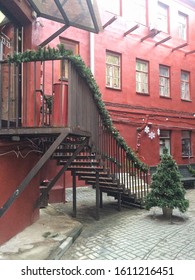 Black metal staircase with green tree in red courtyard
