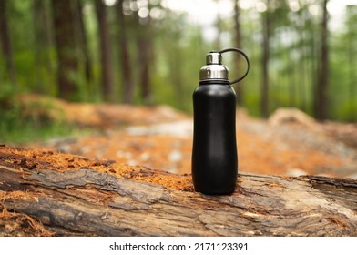 Black metal thermo bottle in the forest - Shutterstock ID 2171123391