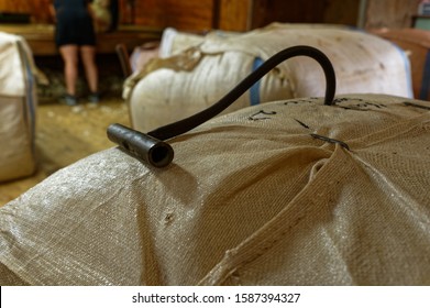 A Black, Metal Wool Bale Hook Is In A Wool Bale In A Shearing Shed