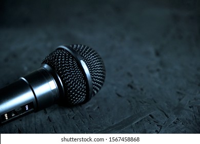 Black microphone dropped to the black wooden floor.Musical instrument for singing and karaoke.