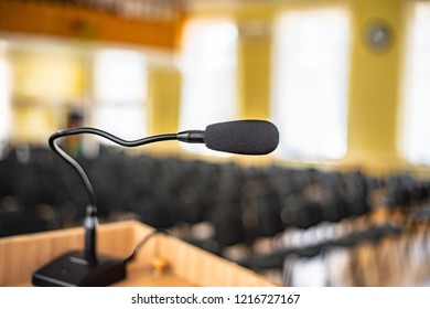 Black Microphone In An Empty Conference Hall, Empty Chair, Ready For Public Speaking