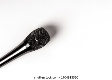 Black microphone on isolated white background, space for text