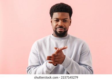 Black mid man with beard smiling and rubbing his hands isolated over pink background - Powered by Shutterstock