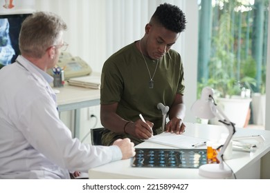 Black Military Man Signing Documents In Medical Office