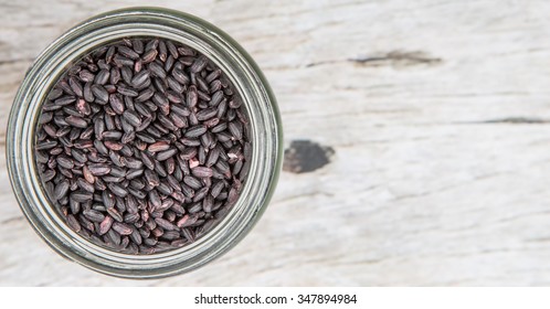 Black Millet Grain Seed In A Mason Jar Over Wooden Background