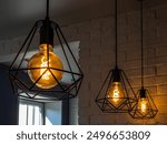 black minimalist loft chandelier with LED filament lamps in a Scandinavian interior