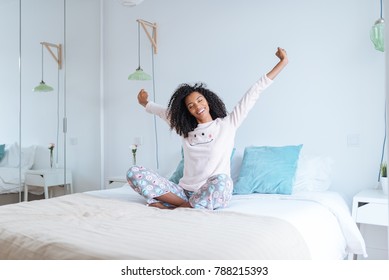 black mix race woman on bed stretching  - Powered by Shutterstock