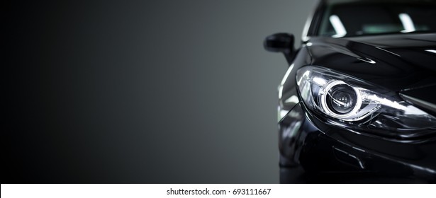Black modern car closeup on black background.