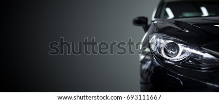 Black modern car closeup on black background.