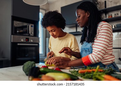 Black Mom And Daughter Are Cooking Vegetables In The Kitchen