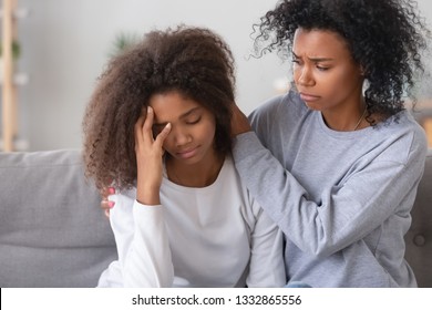 Black Mom Kid Sitting On Couch, Mother Calms Frustrated Daughter, Older Sister Make Peace After Quarrelling With Younger Relative Person. Teen Problems, Emotional Disorders First Unhappy Love Concept