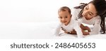 Black Mom Posing With Baby Toddler Holding Helping Her Son Crawl On White Studio Background. Happy Young Mother Caring For Child Infant Bonding And Playing With Cute Little Boy. Panorama, Copy Space