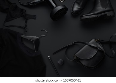 Black monochromatic flatlay on black background. Clothes, accessories and beauty equipment. Black friday sale concept. Copy space - Shutterstock ID 1537053461