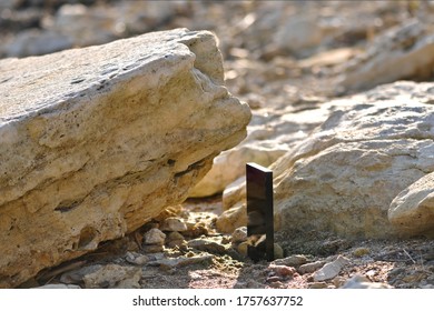 Black Monolith On Old Sandstone Rock Near The Sea Coast