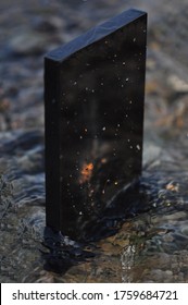 Black Monolith In River Stream