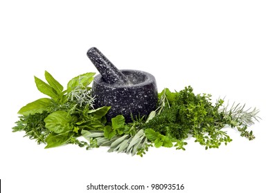 Black mortar and pestle with fresh picked herbs, over white background.