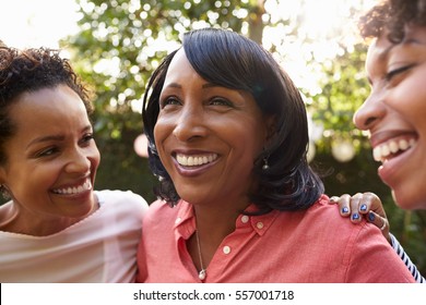 Black Mother And Two Adult Daughters In Garden, Close Up