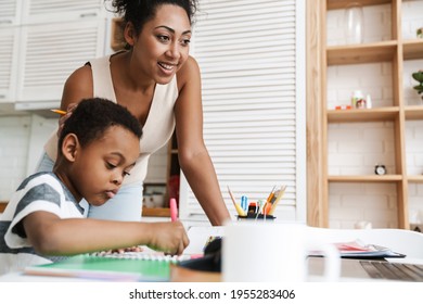 Black mother using laptop while doing homework with her son at home - Shutterstock ID 1955283406