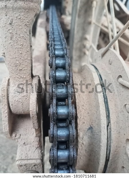 The\
black motorcycle chain on the wheel with engine\
oil.