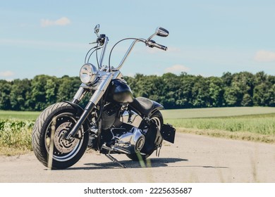 motocicleta negra sin conductor parada en un camino de tierra, vista lateral