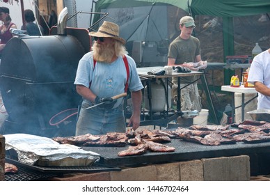 Black Mountain, NC / USA - August 10, 2008:  Older Man Outside Grilling Ribs At A Local Fair In Black Mountain, NC Showing The Extra Large Grill.