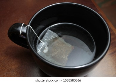 Black Mug With A Bag Of Te. Close Up