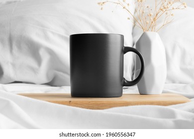 Black Mug Mockup And A Gypsophila On The Bed.