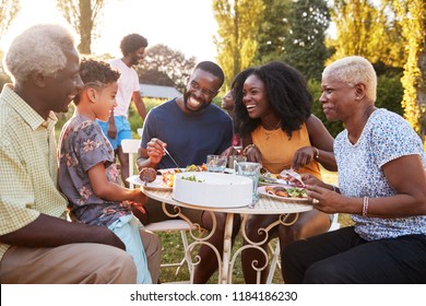 Black Multi Generation Family Eating At A Table In Garden