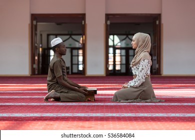 Black Muslim Man And Woman Praying In Mosque