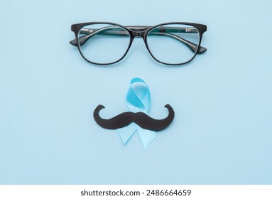 black mustache on blue prostate cancer ribbon and glasses on blue background - Powered by Shutterstock