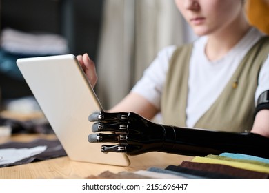 Black myoelectric arm prostthesis of seamstress using tablet by workplace - Shutterstock ID 2151696447