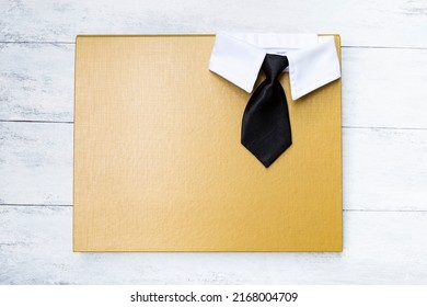 Black necktie with white shirt collar on yellow folder, business concept background, father's day background idea