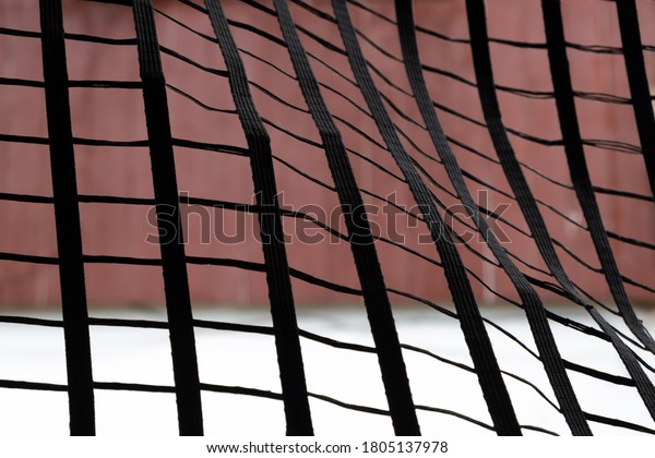 A black net stretched with a red-white\
building background.