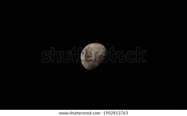 Black\
night sky closeup view of bright side of the moon sphere planet\
star from Huacachina desert Peru South\
America