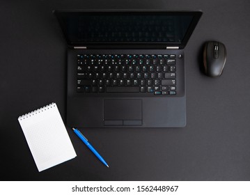 black notebook and black mouse and white note on black desk